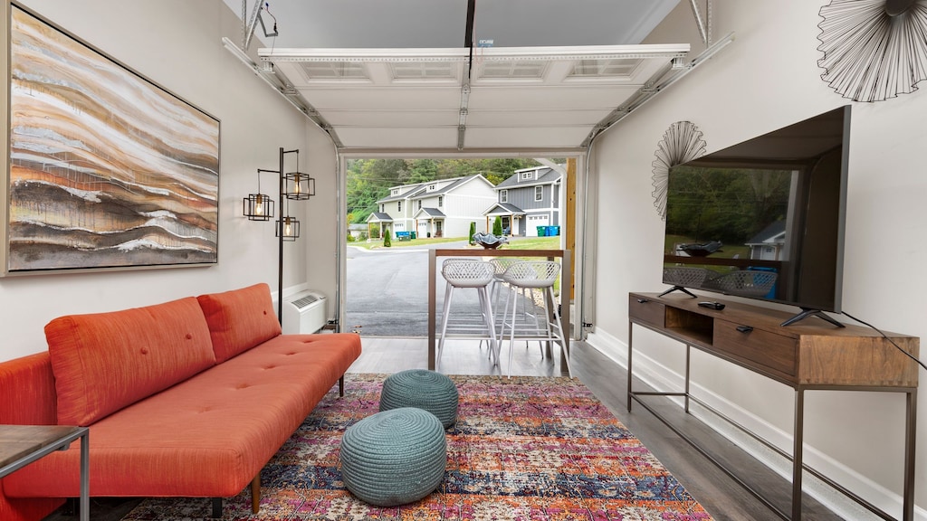 Converted garage lounge at Sweetgum features a sleep sofa, TV, and table.