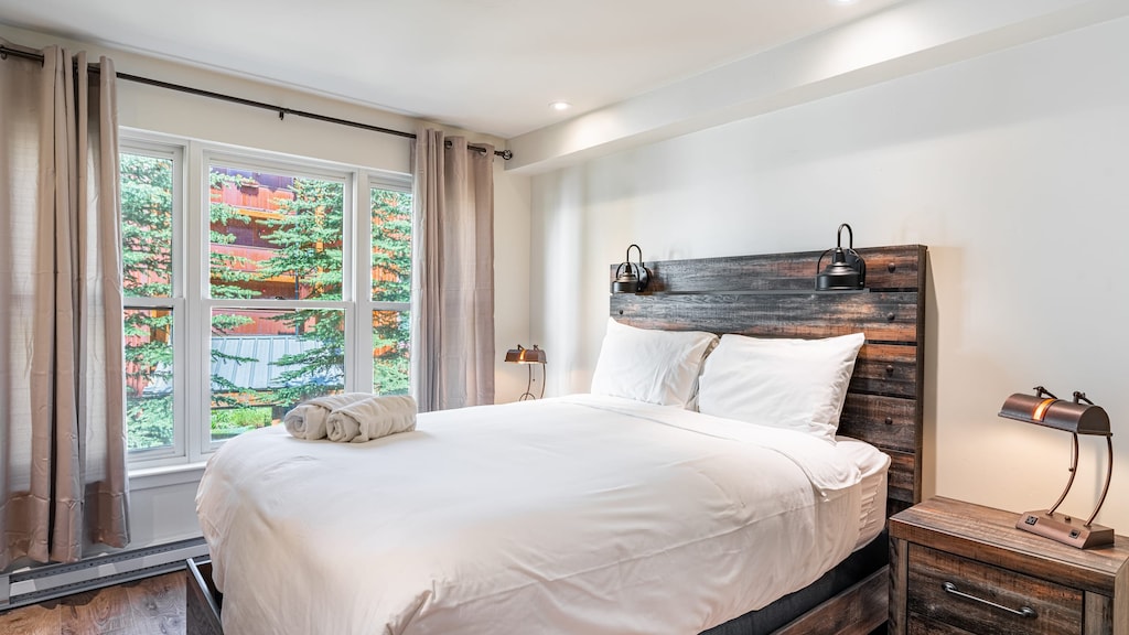 Comfortable bedroom features a queen bed and TV.