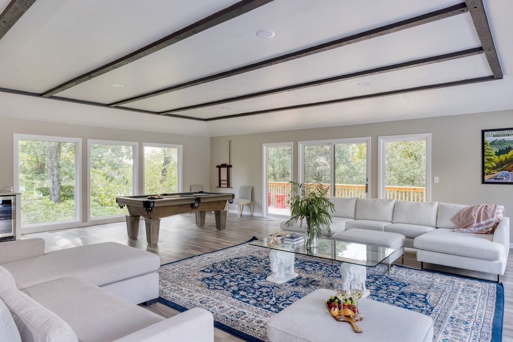 Pool house living room features large windows, tons of natural light, and a pool table.