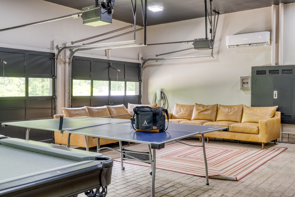 Main home's converted garage game room boasts an oversized sitting area, pool table, ping pong table, and shuffleboard table.
