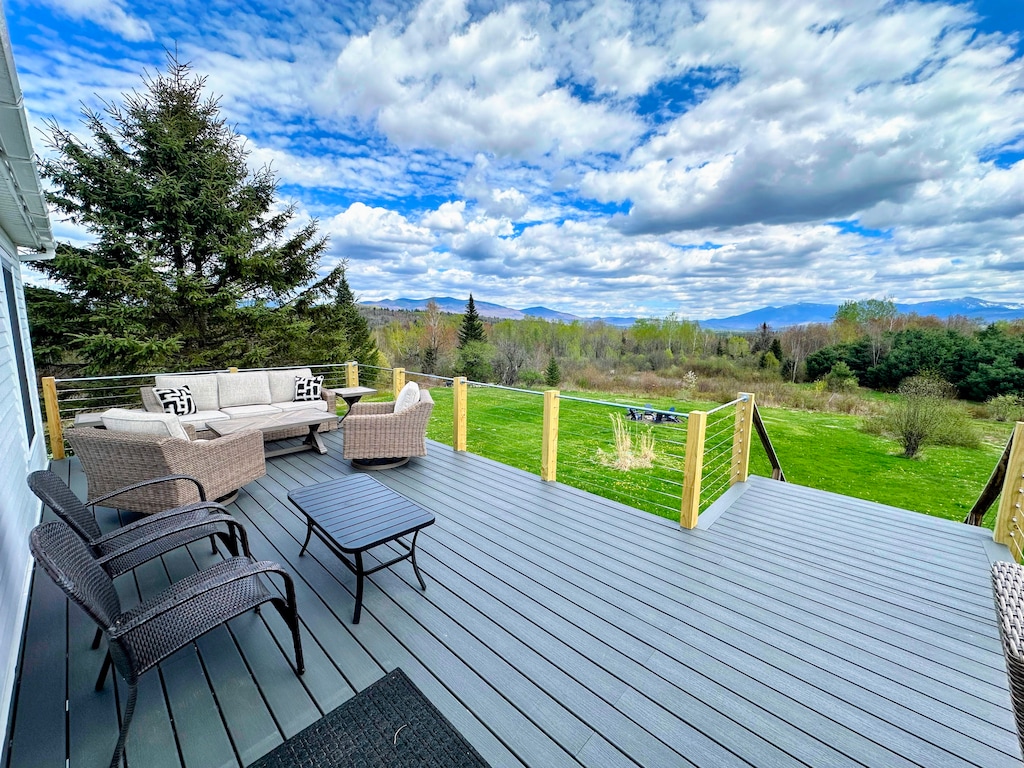 Back deck with sitting area, and dining table.