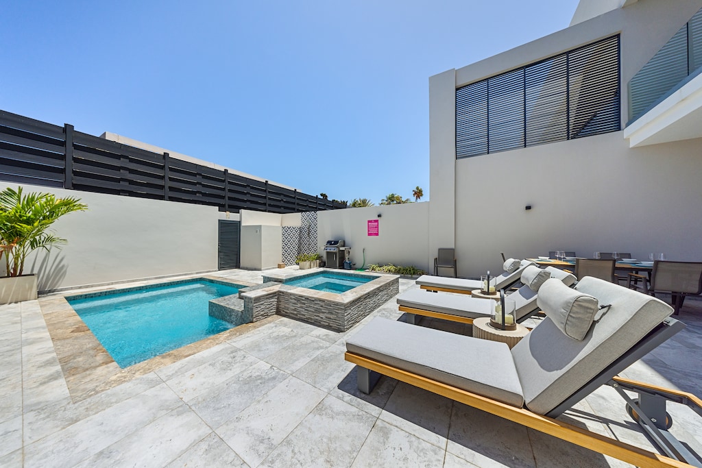 Dive into luxury at sparkling private pool and hot tub of the apartment in Noord Aruba - Where every splash promises a refreshing escape from the ordinary - Inviting poolside loungers for basking in the sunshine and relaxation in modern comforts