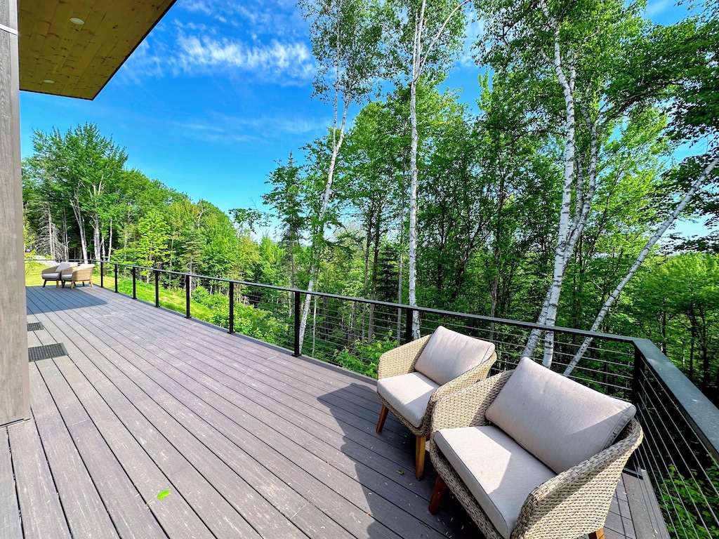 Large spacious deck with seating and mountain views.