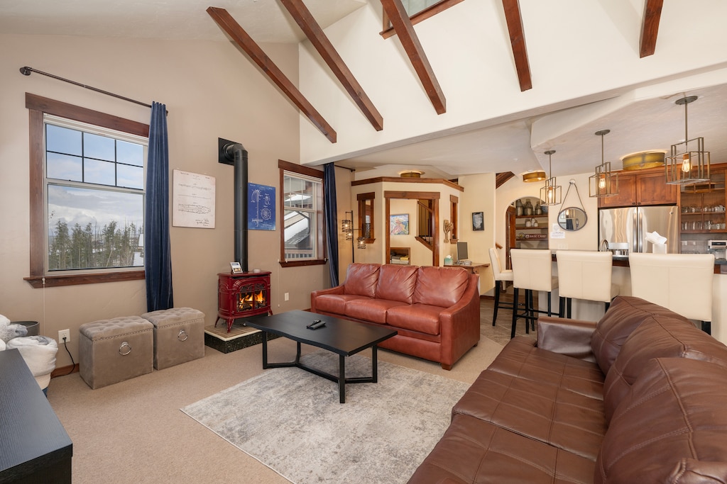 - Cozy living room with leather sofas and wood-beam ceiling   - Warm up by the fireplace after skiing or mountain adventures   - Open layout connects to kitchen and dining for easy gathering