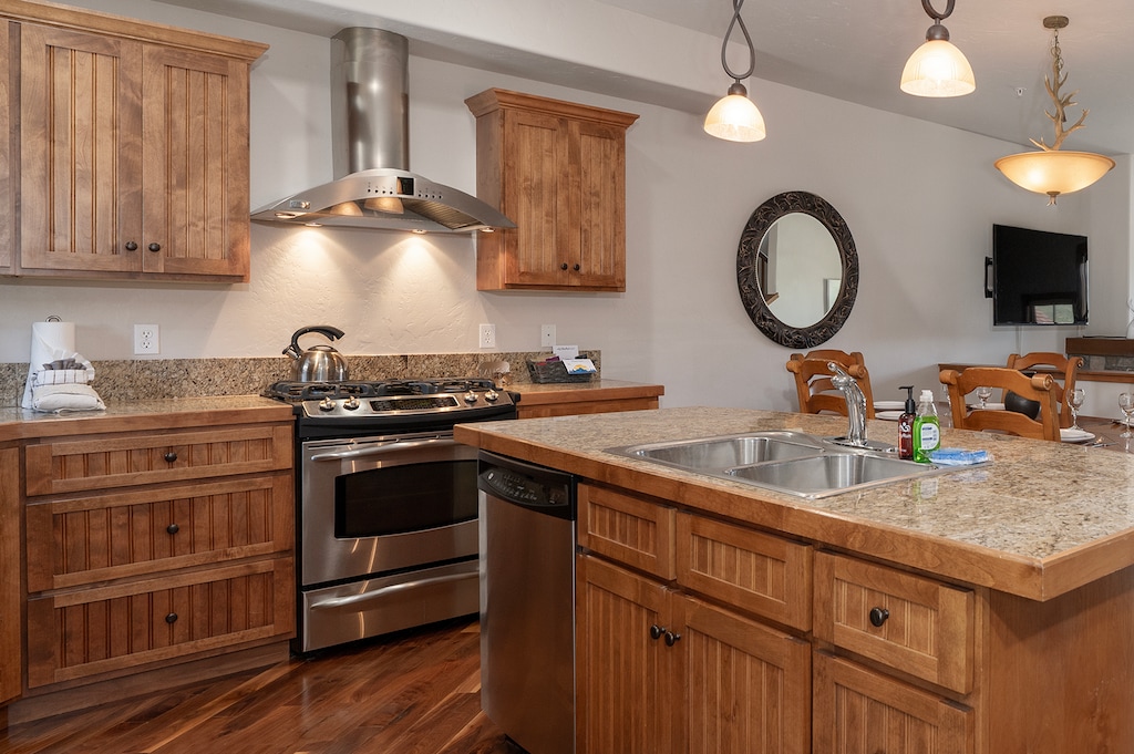 - Stainless steel oven, hood, and dishwasher make cooking a breeze during your stay - Granite counters and pendant lighting offer style and function in one space - Opens directly to dining and living areas for effortless entertaining