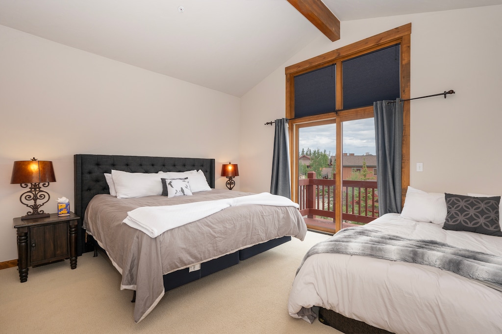 - Vaulted ceilings and mountain views define this airy bedroom with balcony access - Features a king bed and cozy twin daybed, ideal for families or couples - Wooden beams and soft linens add a rustic modern mountain feel