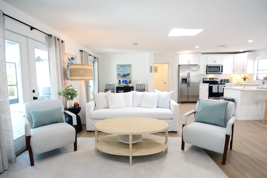 Main living area with plush couch and floor to ceiling patio doors overlooking the pool.