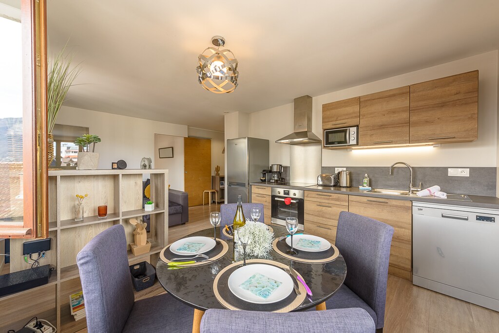 Discover this bright living room, where comfort and functionality meet. Furnished with care, it includes a comfortable corner sofa, a round dining table for four, and a fully equipped kitchen with oven, microwave, Nespresso coffee machine, induction hob and full set of crockery. Enjoy breathtaking views of the majestic surrounding mountains and the Impérial Palace d'Annecy, with even a view of the lake to complete this idyllic picture. (4th floor apartment)