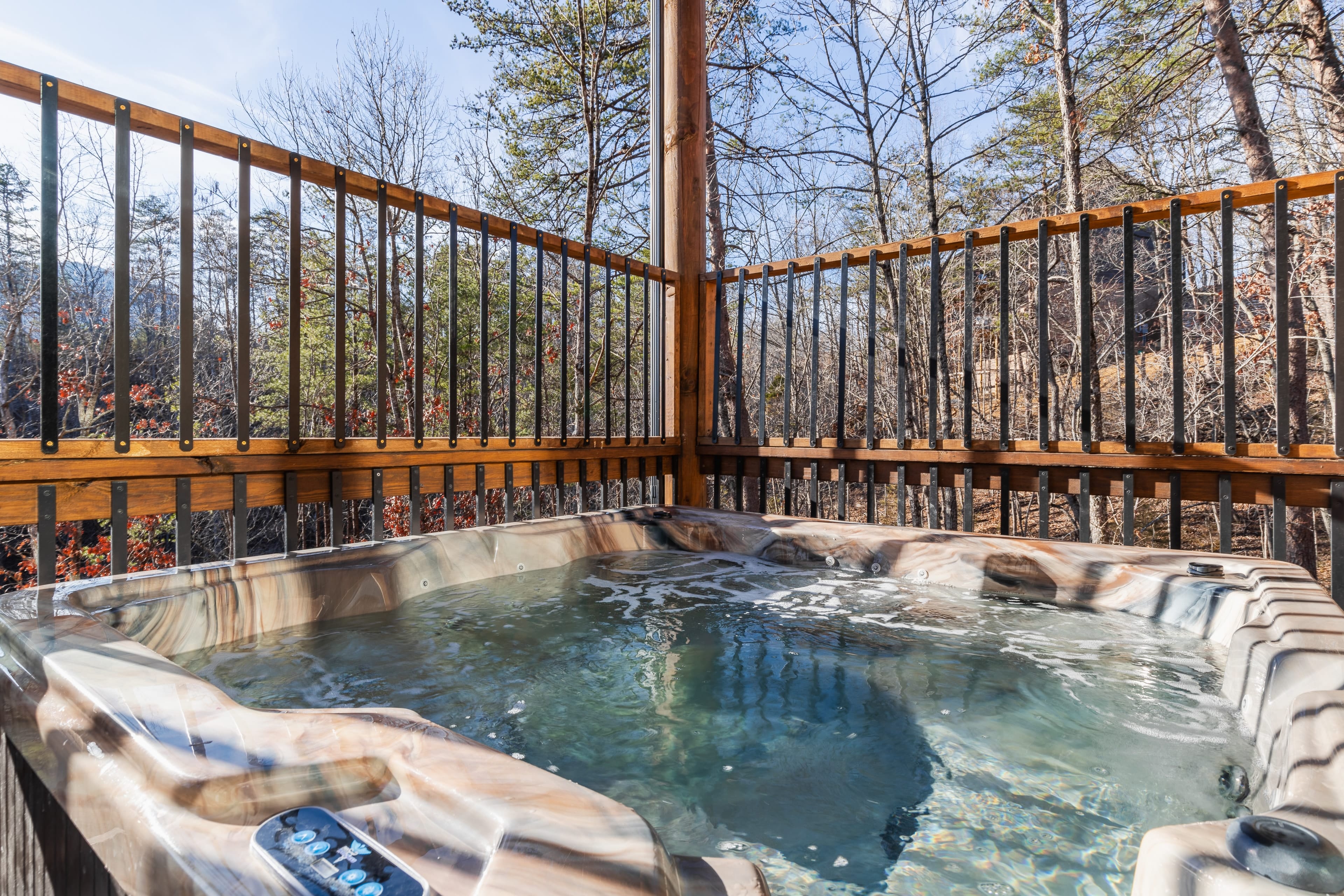 Hot tub on the balcony with stunning forest views.