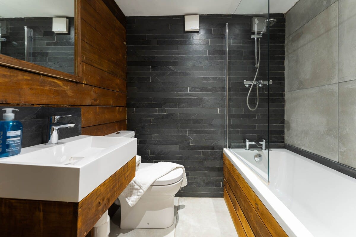 Contemporary family bathroom suite with fresh large towels, hand towels and guest toiletries.