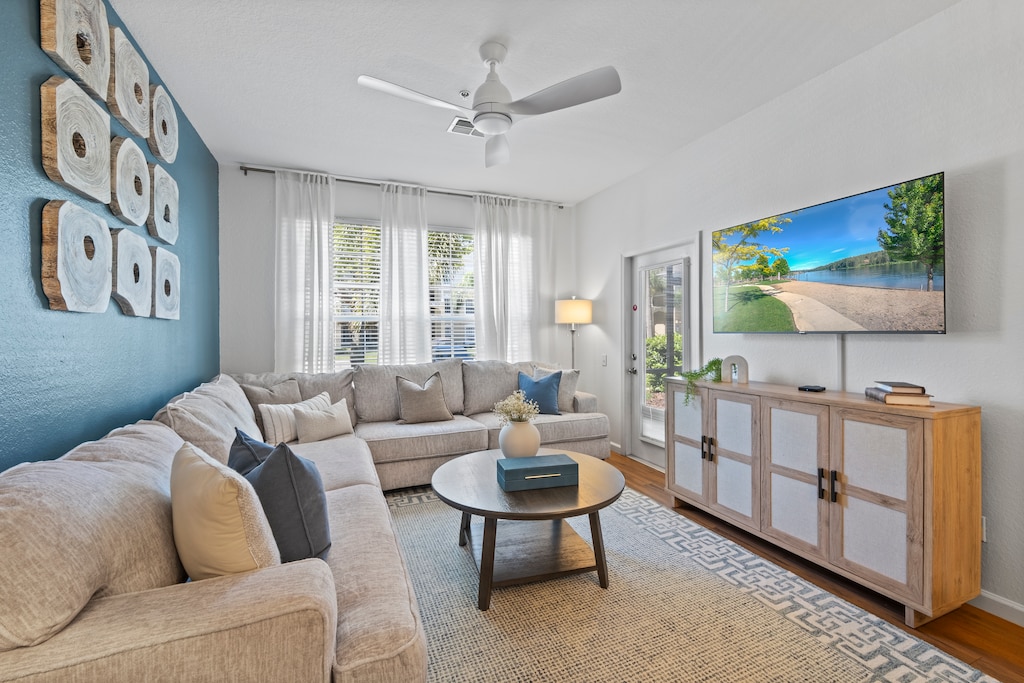 Modern living room of the condo in Kissimmee, Florida - Cozy couches for relaxation - Thoughtfully arranged furniture blending comfort with elegance - Carefully selected lighting fixtures, balancing practicality with charm - Smart TV with Netflix