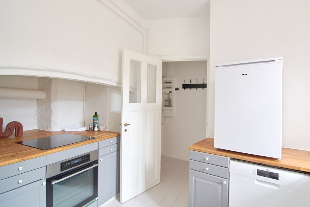 This small yet bright kitchen boasts large windows that let in plenty of natural light, creating a warm and inviting atmosphere.
