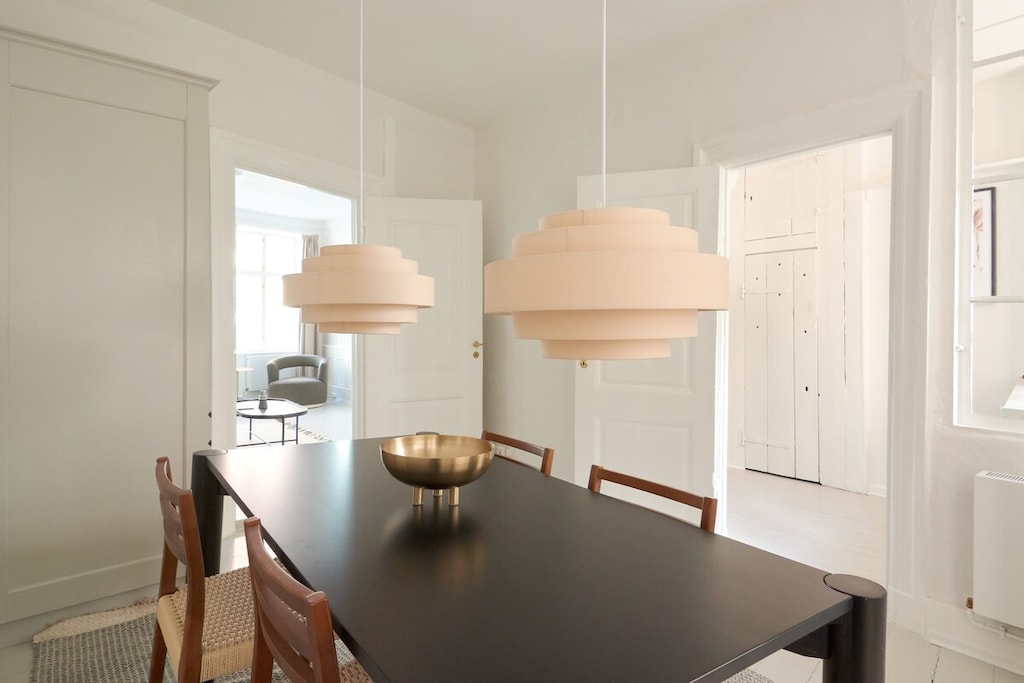 The contrast between the black table and wooden chairs creates a stylish and contemporary aesthetic, adding a touch of sophistication to the dining room.
