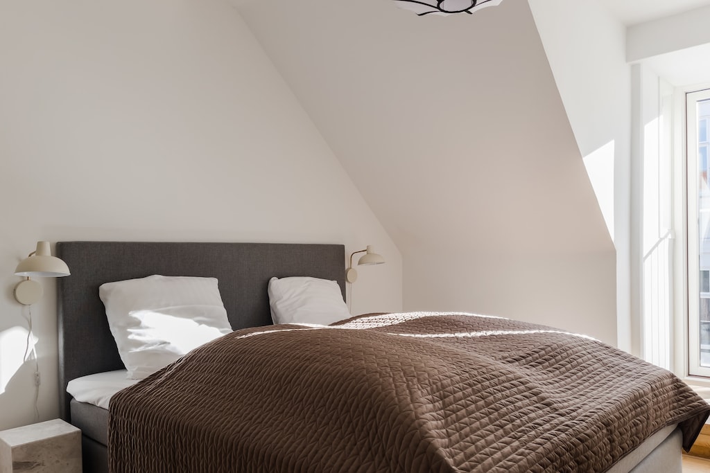 This charming bedroom features white walls that create a clean and fresh ambiance, making it the perfect place to unwind and relax after a long day.