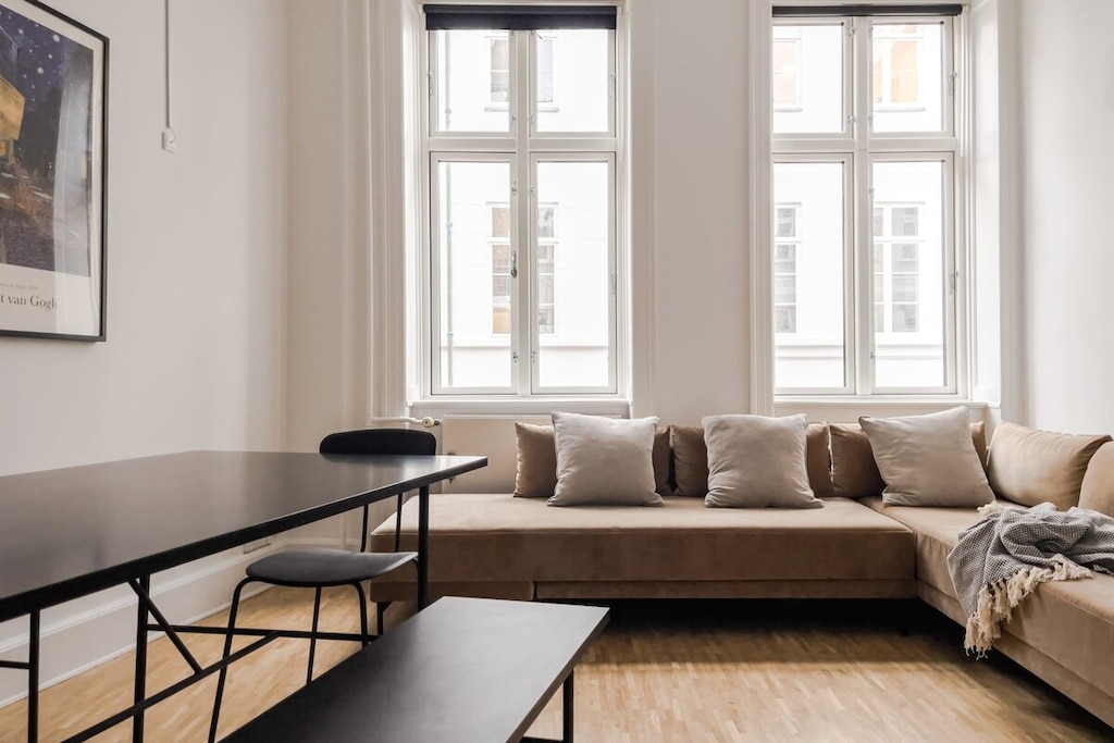 The dining table with bench is positioned near the windows, providing a stunning view of the outside world while also serving as a functional and stylish piece of furniture.