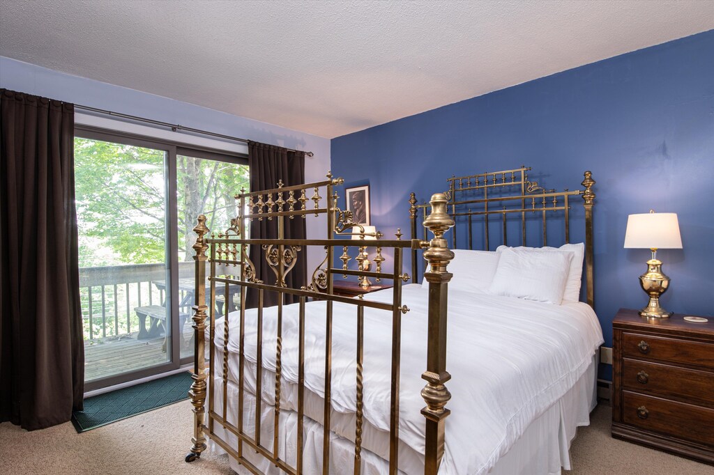 - Spacious bedroom with elegant brass bed frame   - Private balcony access with beautiful outdoor views   - Restful retreat after mountain adventures nearby