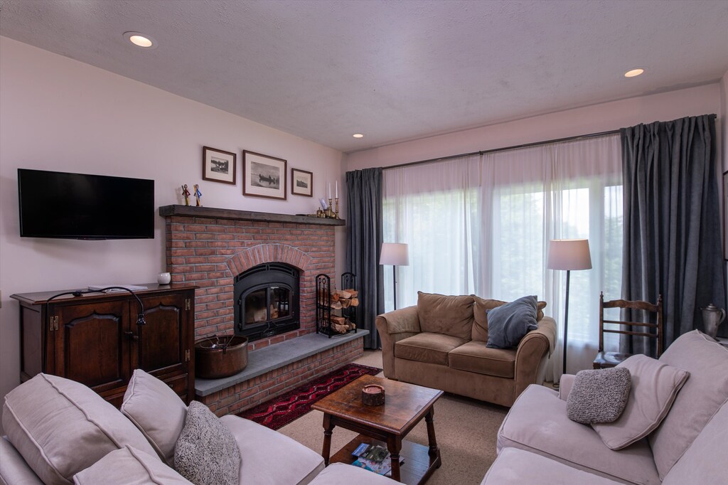 - Cozy living room with a warm brick fireplace   - Comfortable sofas for relaxing after skiing or hiking   - Large windows fill the space with natural light