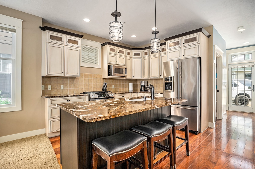 The Kitchen Features Stainless Steel Appliances, a Gas Range and a Bar Top Island