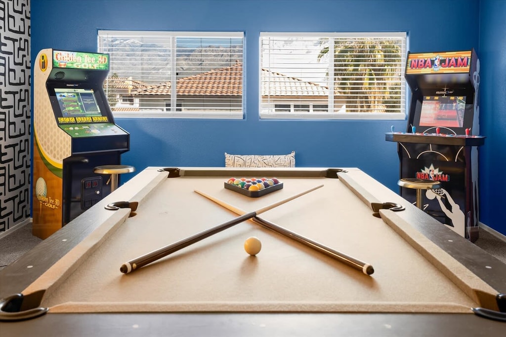 Game room with smart TV, pool table, and arcade games
