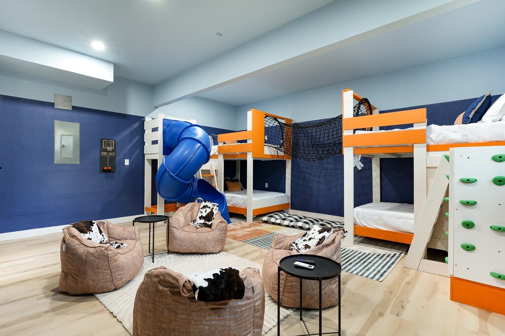 Welcome to our bunk room with twirling slide, climbing wall, and cozy beanbag lounge!