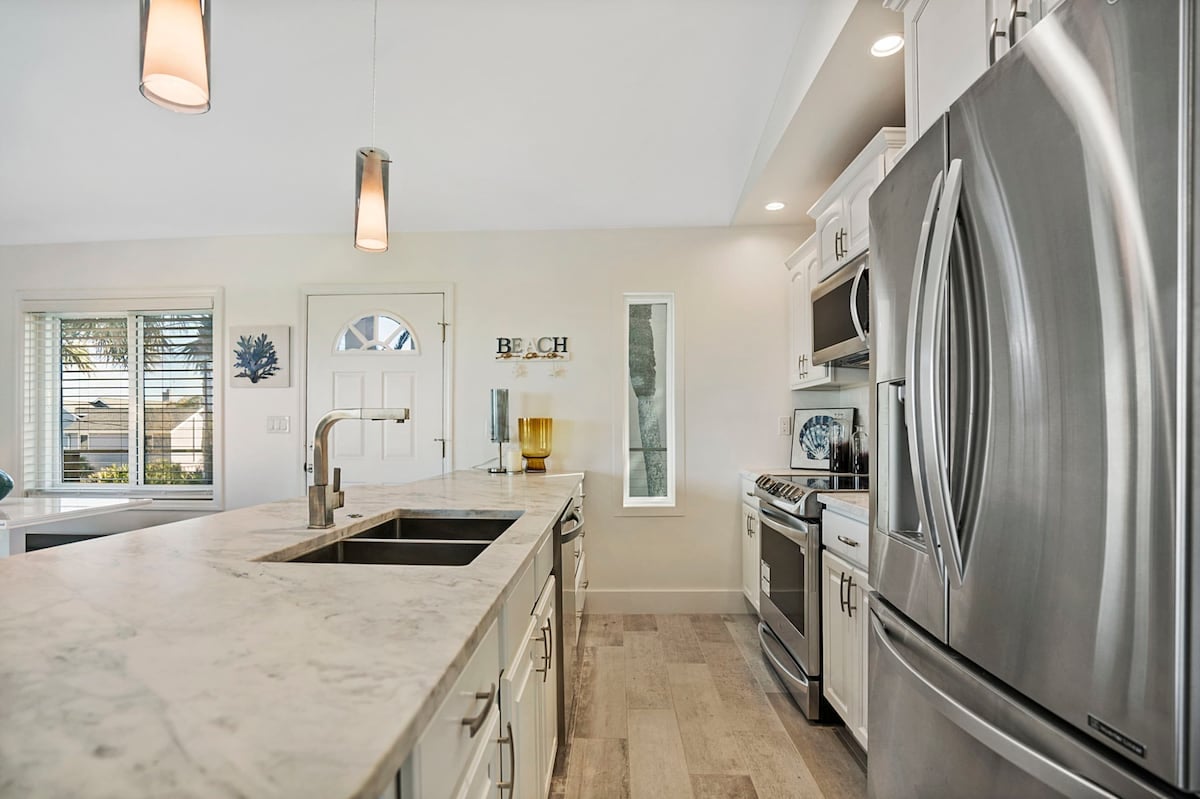 Kitchen with all new stainless steel appliances and cookware.