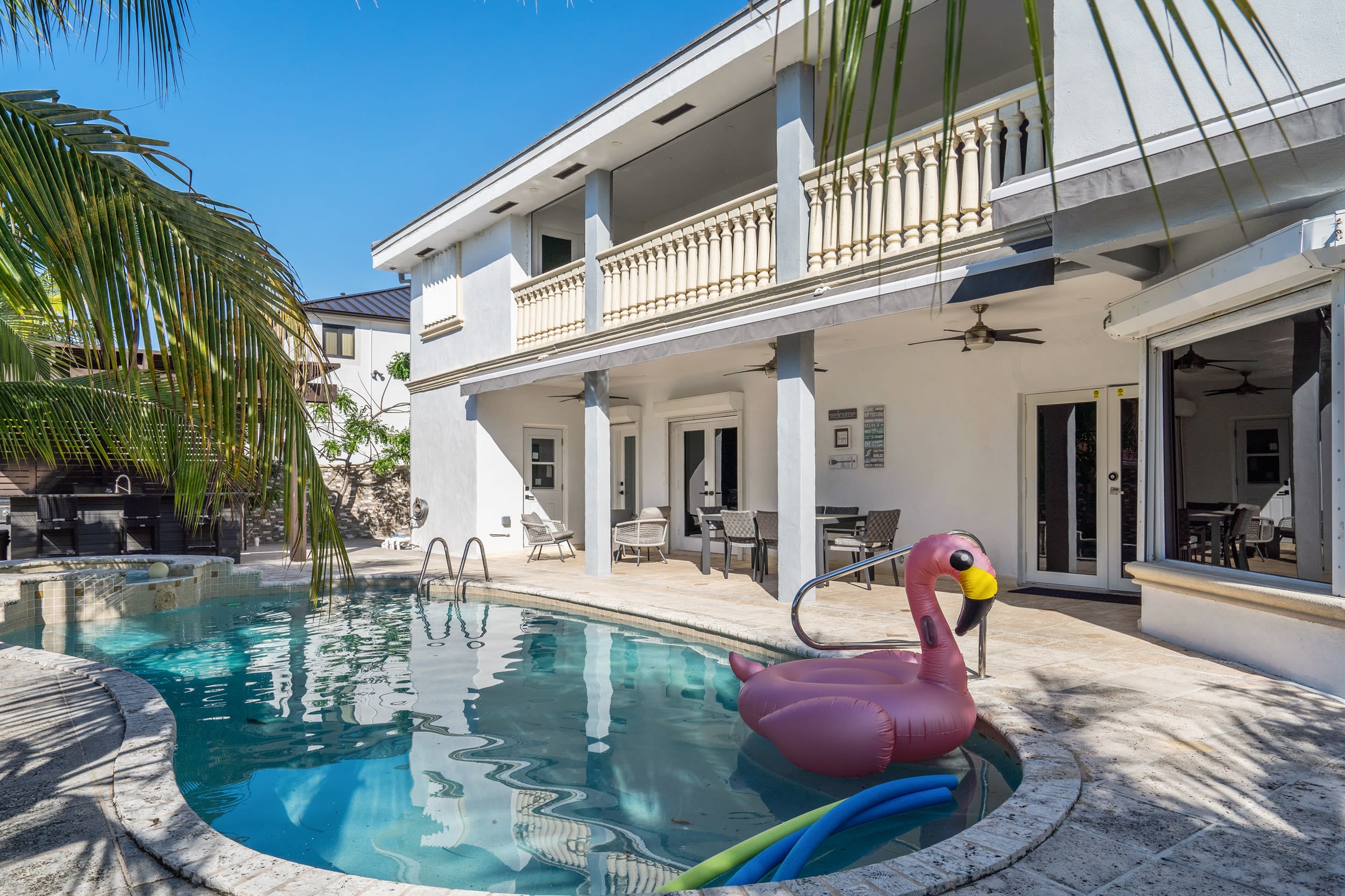 This beautiful free-form outdoor swimming pool is perfect for a cool, refreshing dip; relax on a pool floatie as you take in the beautiful view of the palm trees.