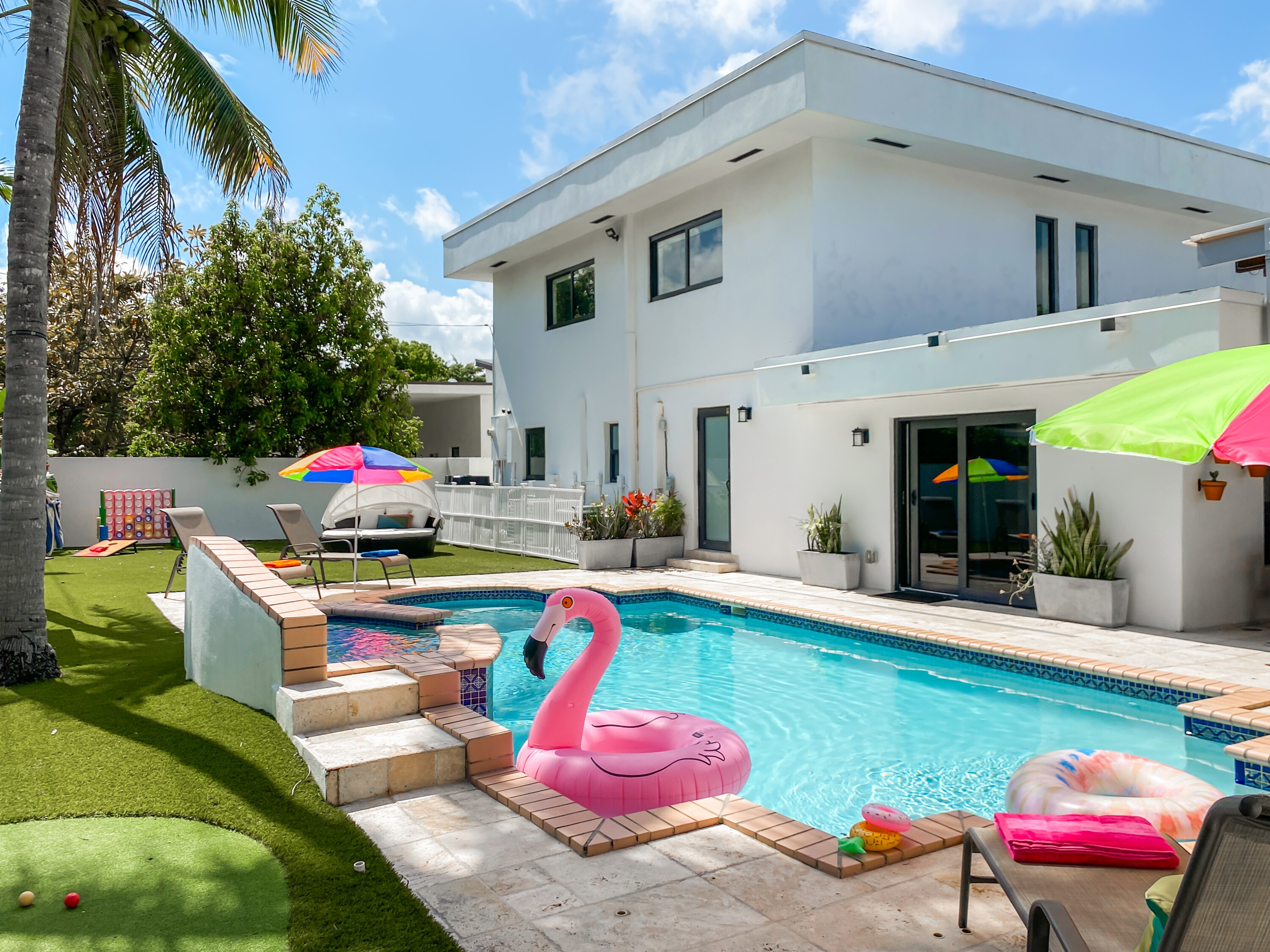 Backyard | Welcome to your outdoor paradise.  Includes a TV, heated pool, loungers, dining table seating, kitchen, BBQ, putt-putt golf, and outdoor games!