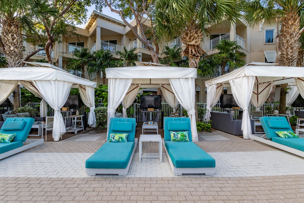 Chic cabanas with loungers and privacy curtains, perfect for sun and shade.