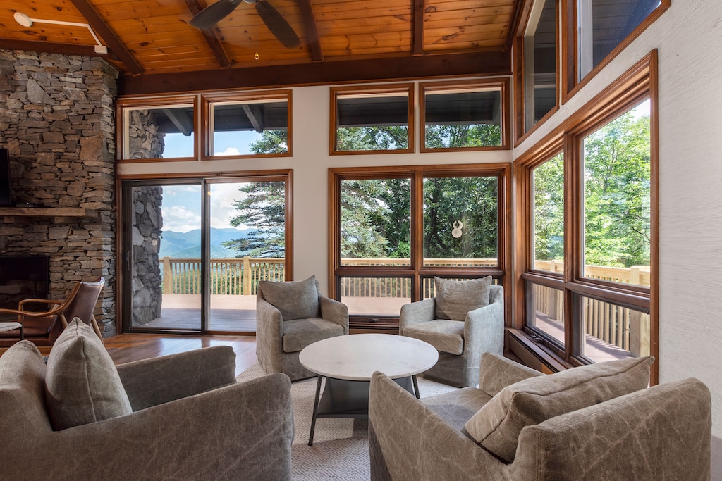 Living room with floor-to-ceiling windows, 55" Smart TV for streaming, gas log fireplace, and sitting area.