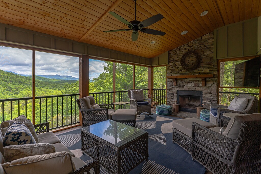 Main floor screened-in porch with TV for streaming and wood-burning fireplace