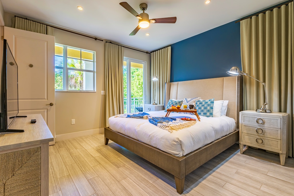 Bright bedroom with king bed, private balcony access, and chic décor.