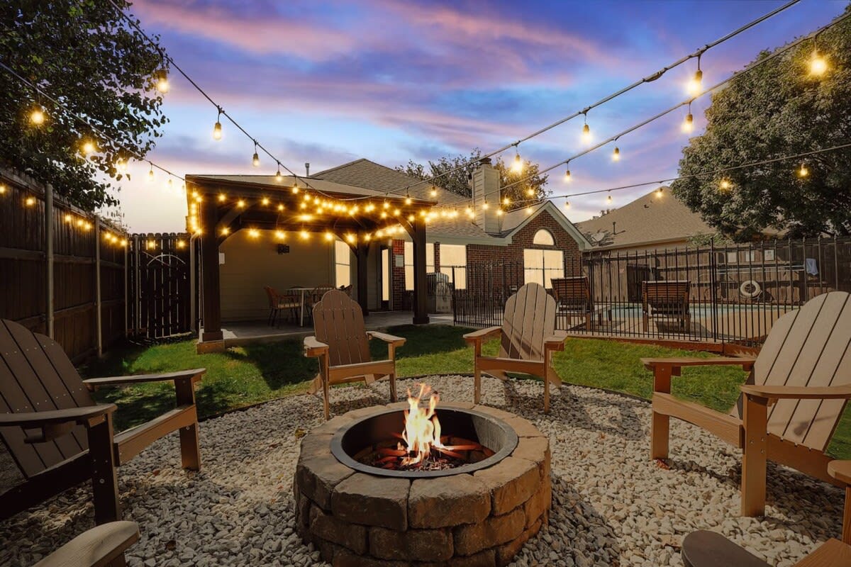 Stay cozy and warm as you chat late into the evening by this decadent fire pit, fully decked out with string lights, Adirondack chairs, and decorative rocks.