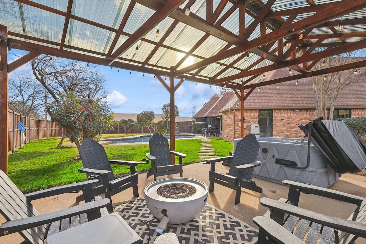 This backyard has everything you need for a relaxing getaway with its outdoor pool, relaxing Jacuzzi, warm fire pit, and beautiful string lights!