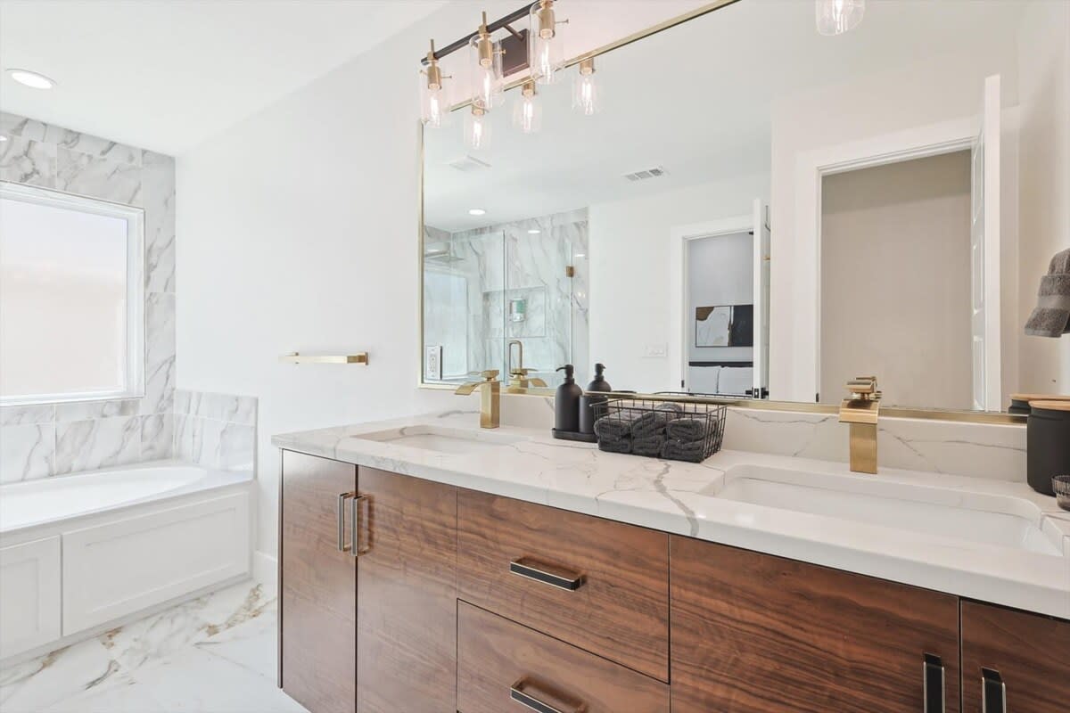 With dual vanities, an oversized mirror, and high-end finishes, there’s plenty of space in this bathroom to prepare for whatever the day may bring!