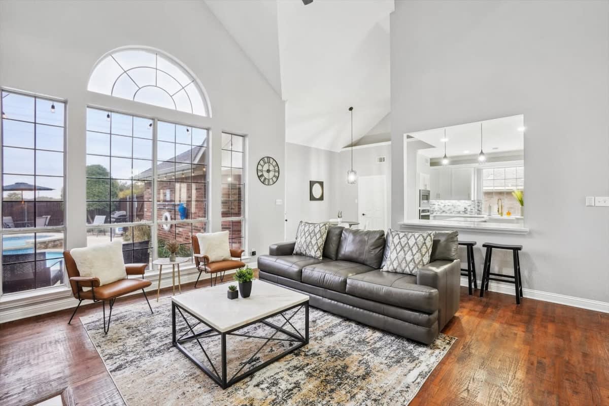 With high-vaulted ceilings and an impressive wall of windows, this living room is a modern, multi-functional space just waiting for you to experience it!