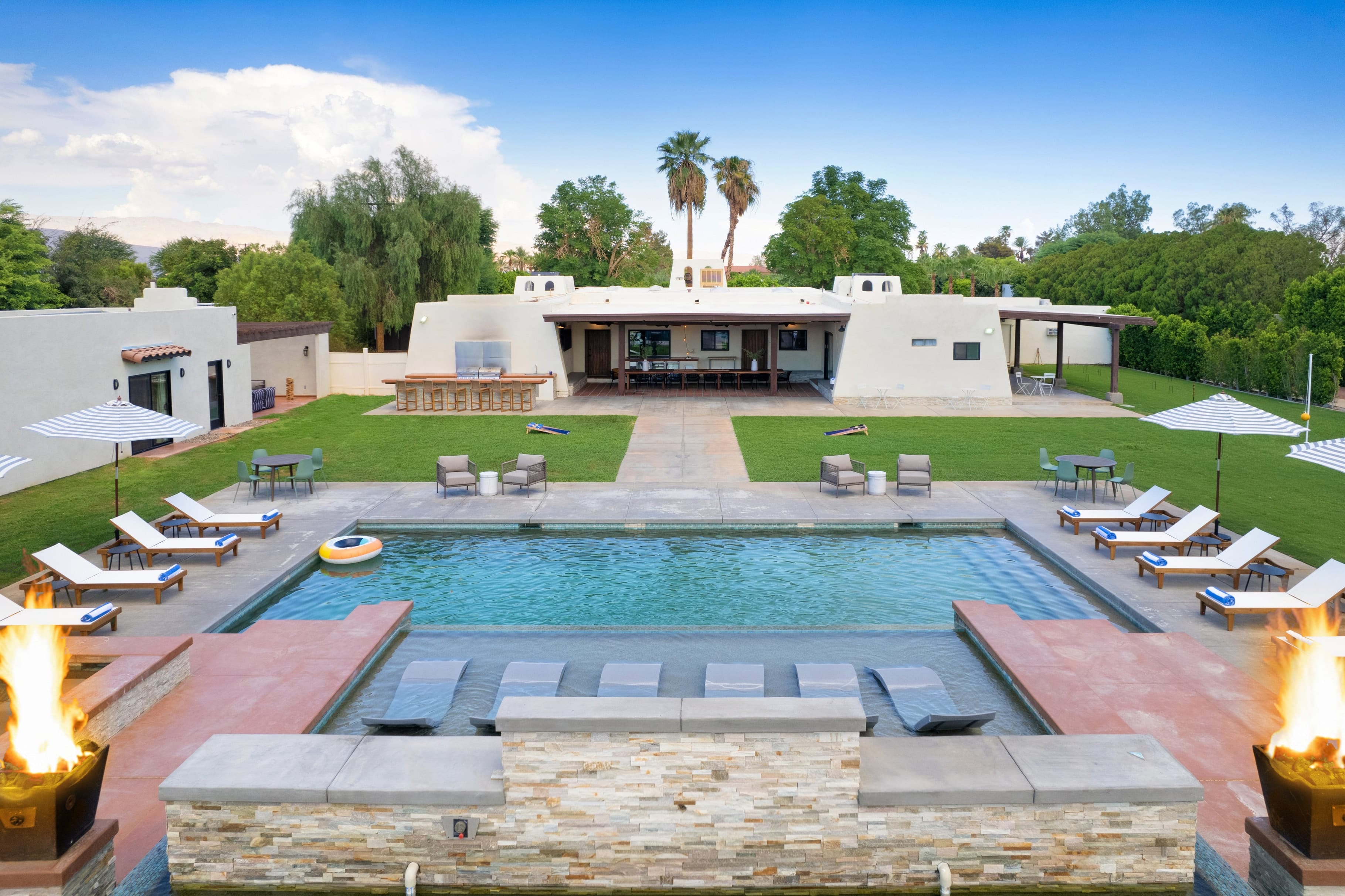 Massive backyard with a pool, hot tub, and entertainment area.