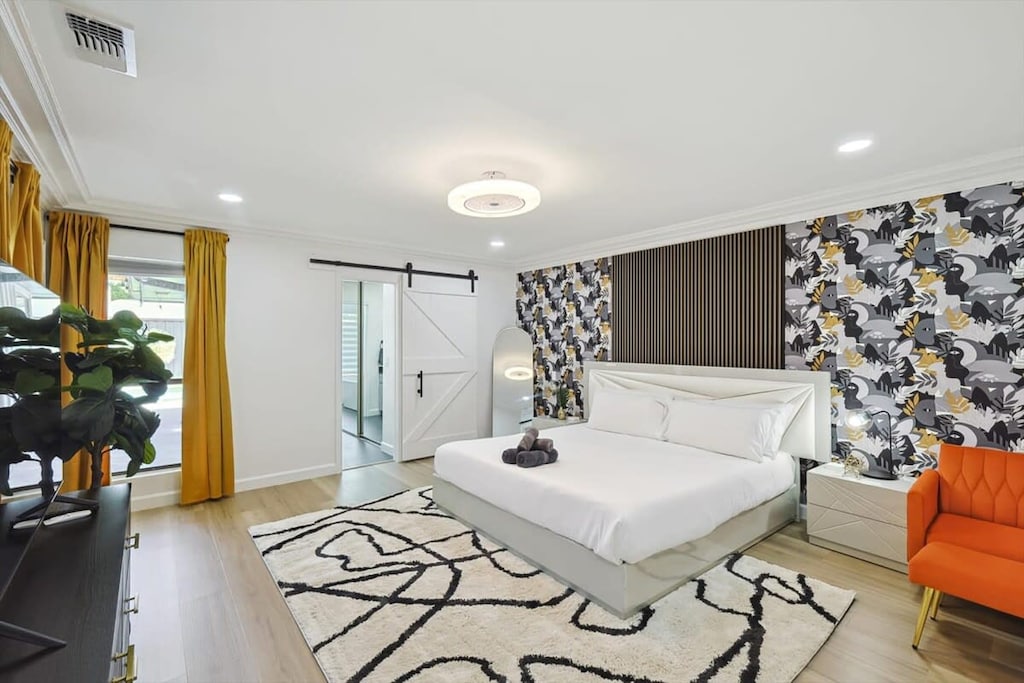 This spacious primary bedroom has all the bells and whistles, including an ensuite bathroom, a dedicated sitting area, and a flat-screen TV!