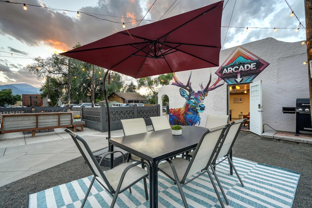 Relax and enjoy meals in our inviting outdoor dining area, complete with a large umbrella for shade."