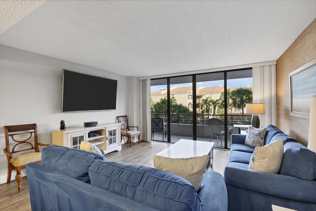 Living Room with lots of comfy seating, 75-inch Smart TV and balcony access