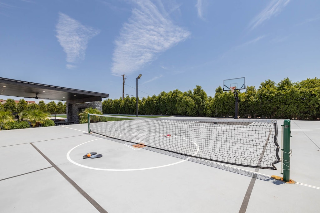 Outdoor sports court featuring both a basketball hoop and pickleball court
