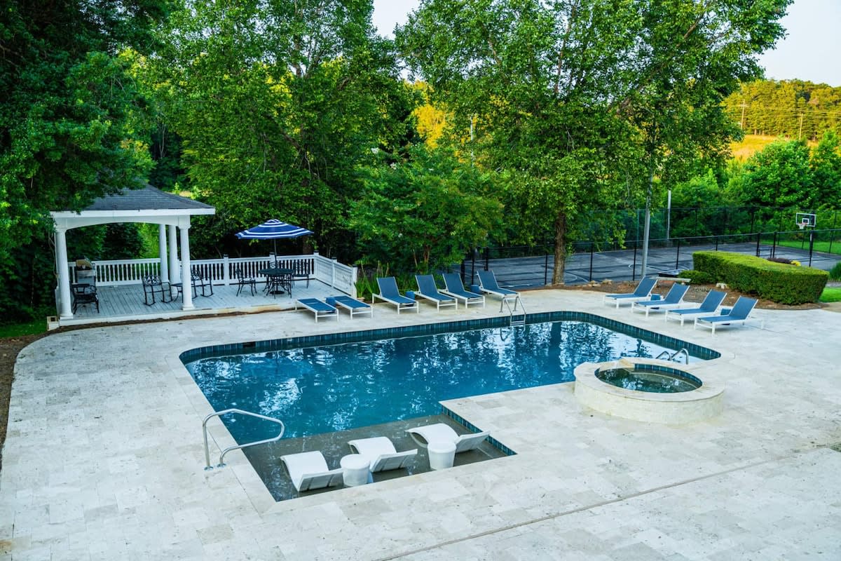 Enjoy the large heated pool with a tanning ledge and  a luxury travertine deck, Hot tub, and gazebo with Grill station.