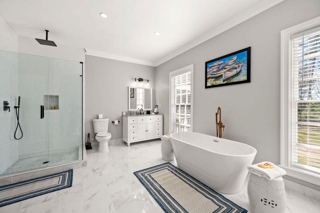 Master Bathroom with two toilets, 2 vanity's, oversized soaking tub, and tiled shower.