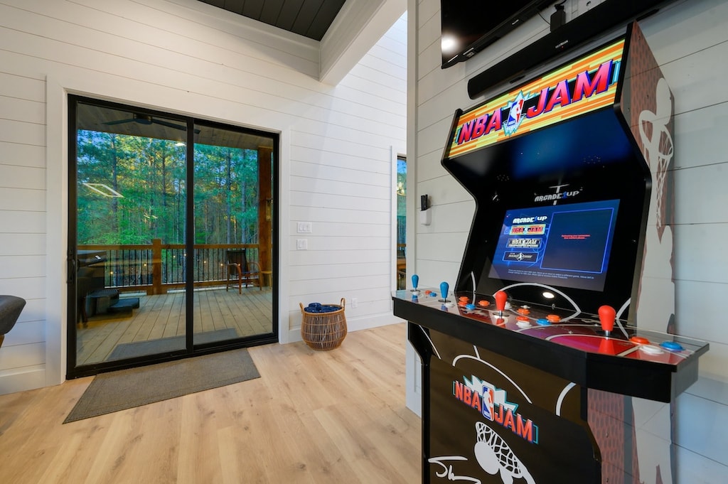 Game room with arcade, card table, darts, and air hockey