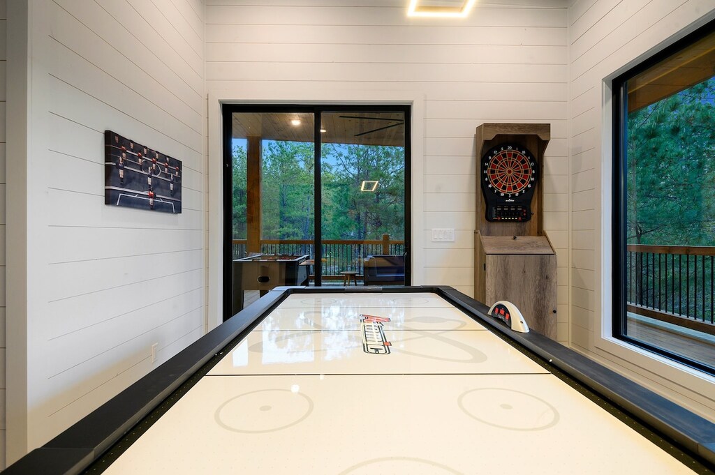 Game room with arcade, card table, darts, and air hockey
