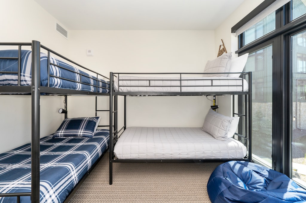 - Cozy bunk room features two twin over full metal bunk beds for flexible sleeping options - Bean bag chair and large window make it a fun hangout for kids or teens - Simple, modern furnishings ensure style and comfort for every age
