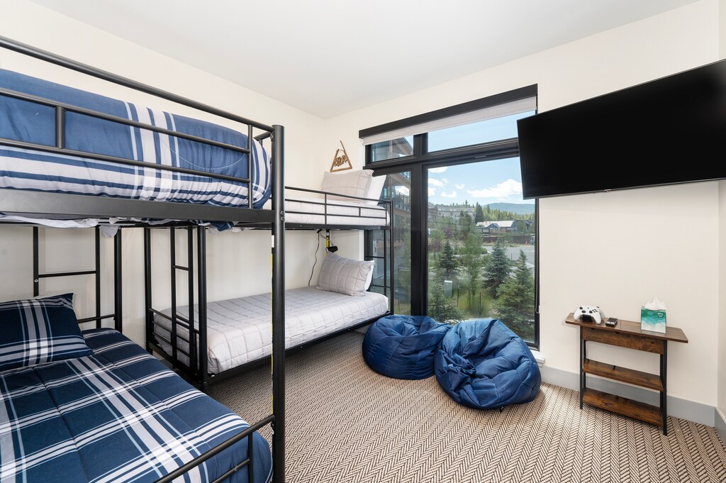 - Playful bunk room features twin over full metal bunks, bean bag loungers, and a wall mounted TV - Large windows frame gorgeous mountain views and flood the space with light - Perfect for kids, teens, or extra guests to relax and unwind