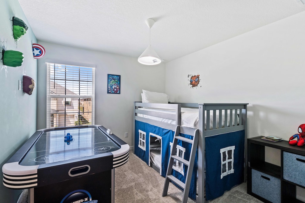 Experience the ultimate kid's haven in our Marvels themed bedroom of the home in Kissimmee - Featuring a bunk bed for cozy sleepovers and an air hockey table for exhilarating entertainment. - Fostering a space for imaginative play and restful sleep