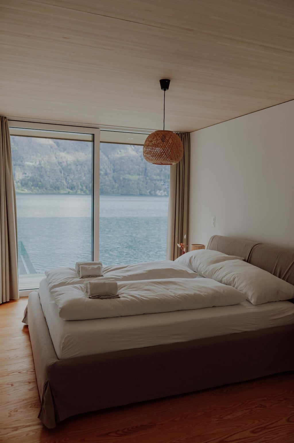 Wake up to the serene view of a calm lake and majestic mountains, all from the comfort of this tranquil bedroom