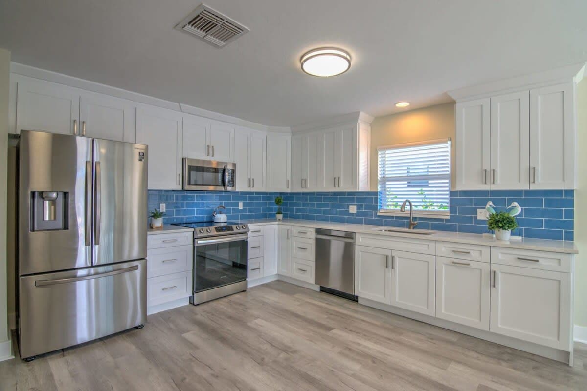 The Kitchen Includes Stainless Steel Appliances and Solid White Cabinets