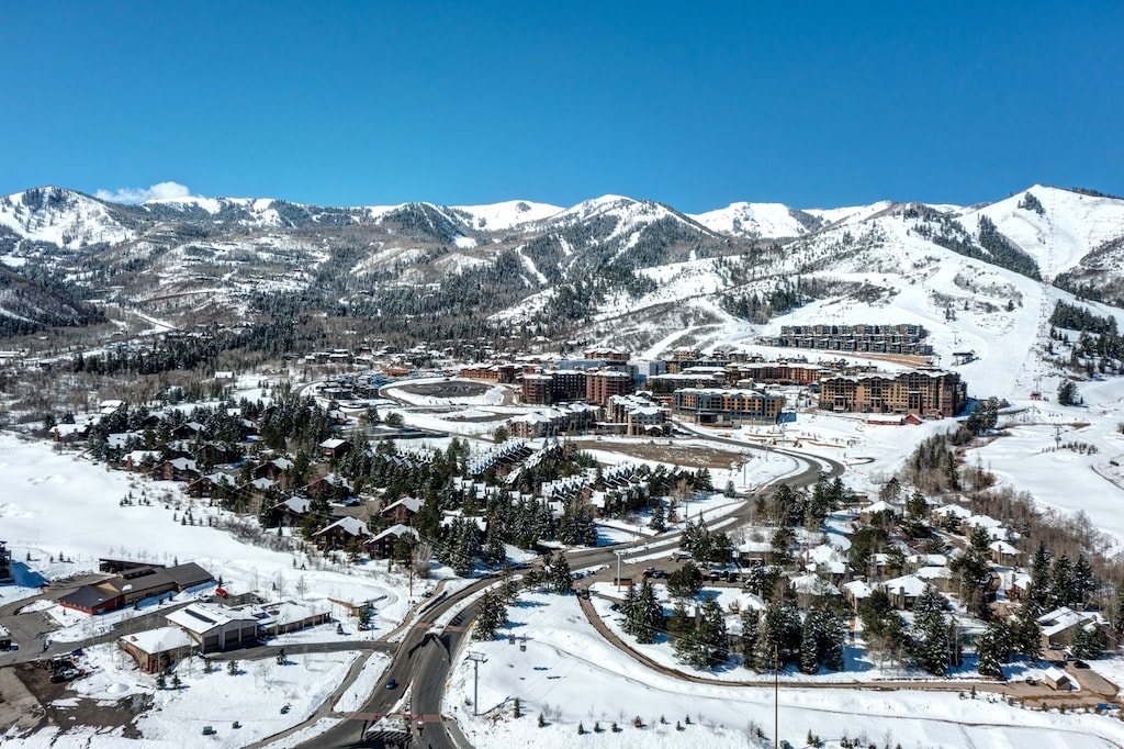 Stunning aerial view of a pristine mountain resort town nestled in snow-covered peaks, showcasing the perfect winter destination.